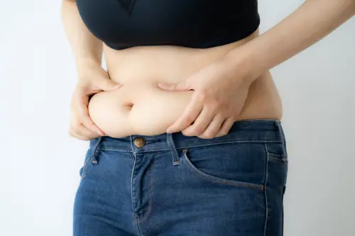 下腹を掴んでいる女性