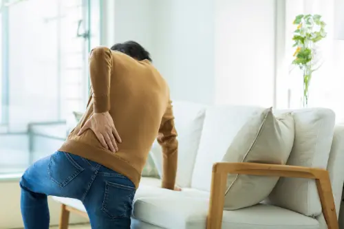 腰を抑えている男性