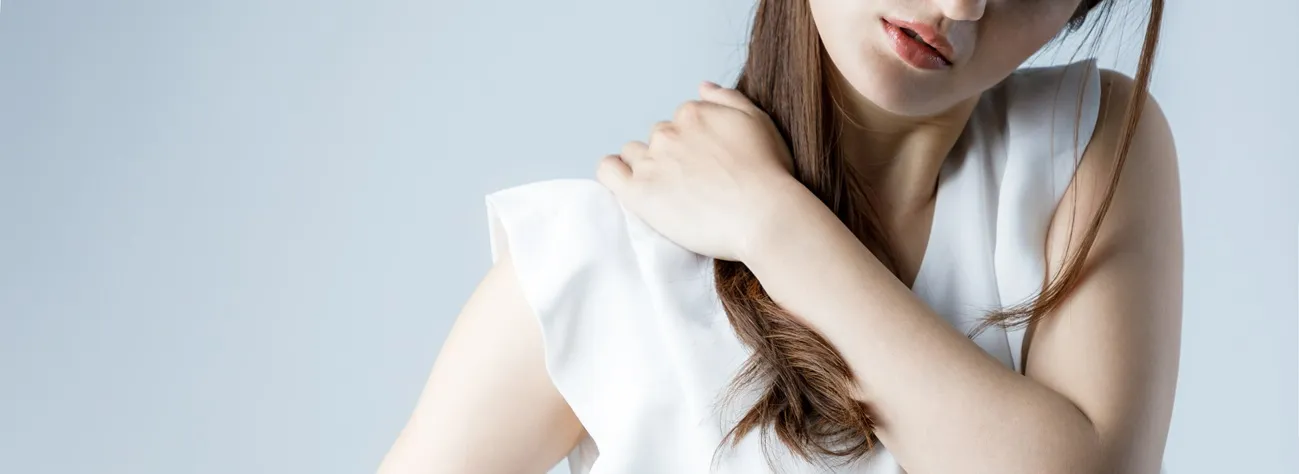 肩を抑えている女性